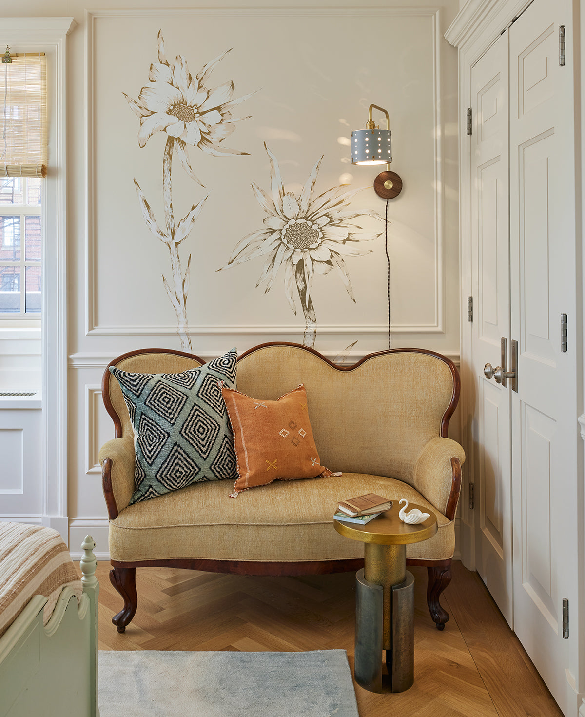 Articulating satin brass sconce with blue handstitched shade and walnut backplate in sitting room