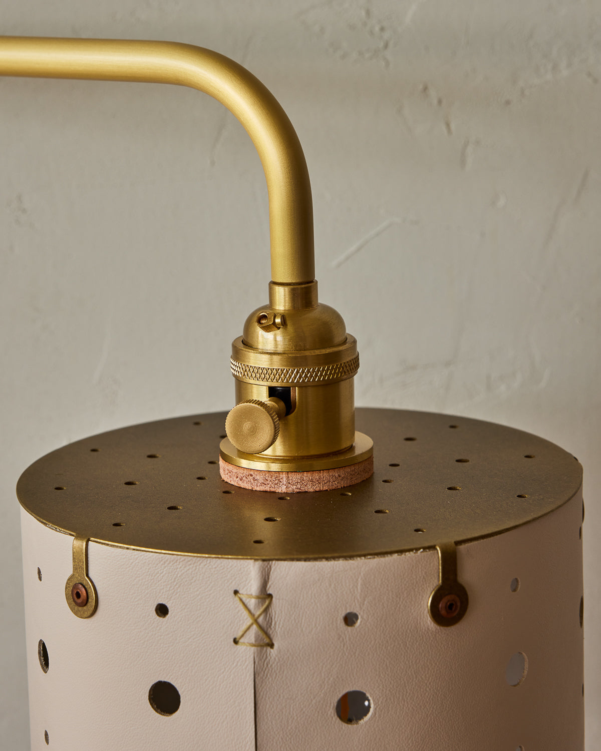 Articulating satin brass plug-in wall sconce with white handstitched shade and walnut backplate
