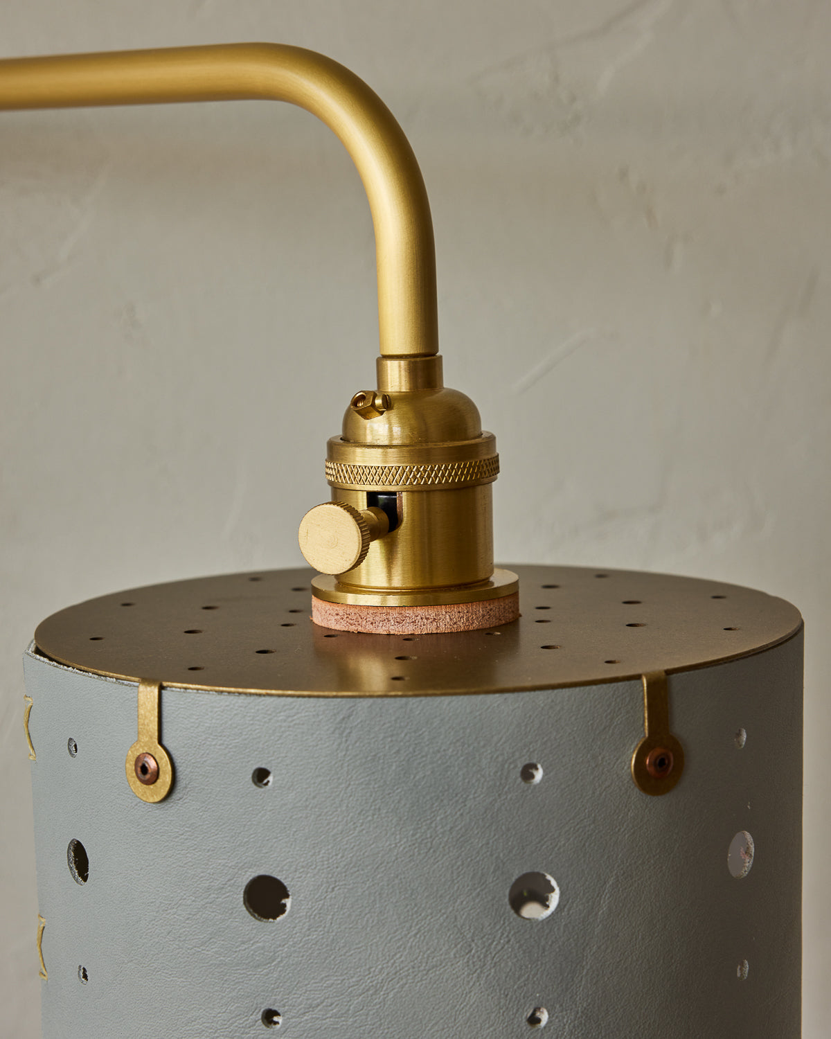 Articulating satin brass sconce with blue handstitched shade and walnut backplate