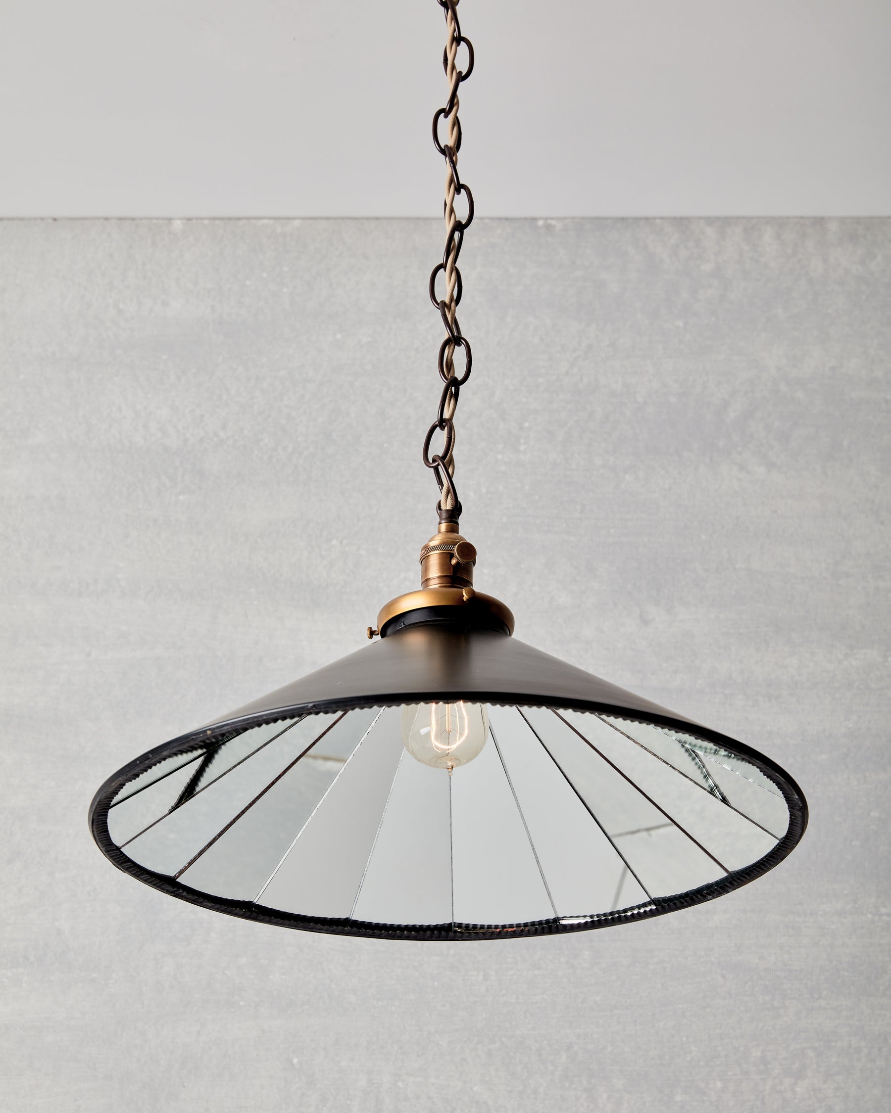 Classic large modern mirrored cone pendant with oil rubbed brass chain. Hardwired light fixture. Simple interior design, made in the USA.