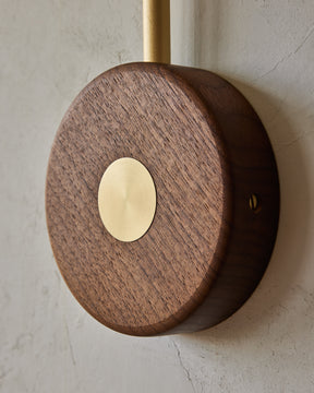 Articulating satin brass sconce with blue handstitched leather shade and walnut backplate