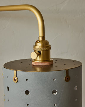 Articulating satin brass sconce with blue handstitched shade and walnut backplate