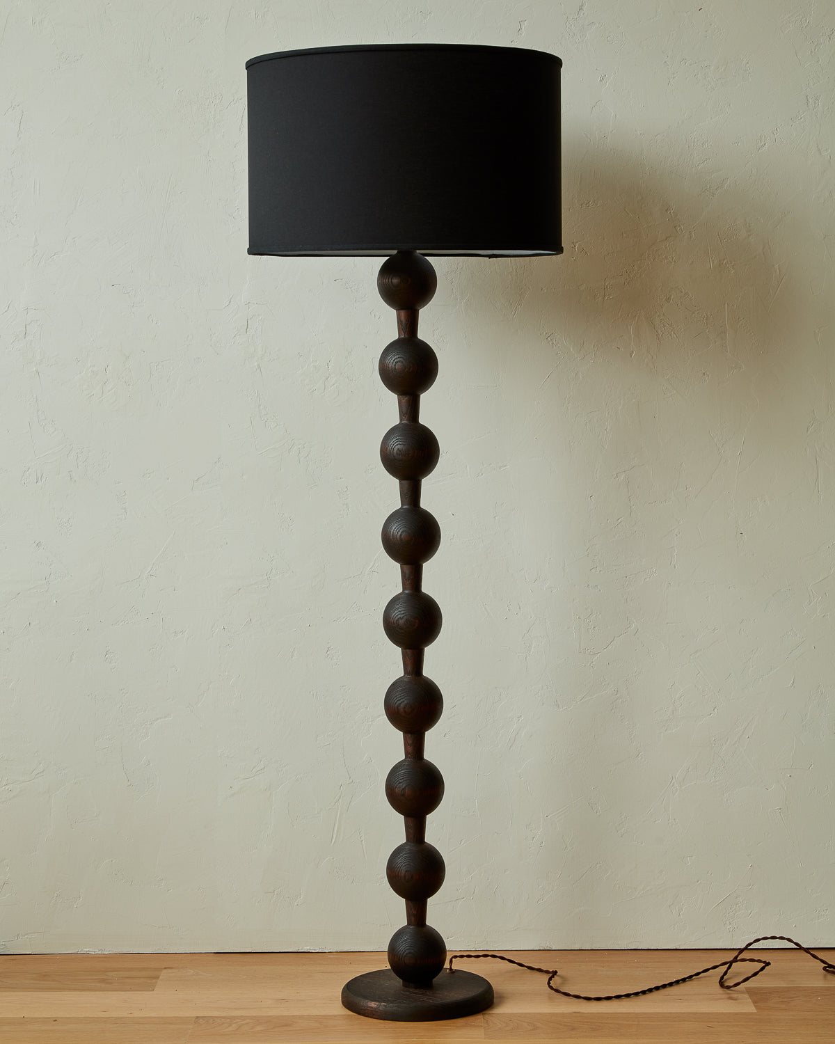 Tall sculptural solid oak floor lamp with barbell design in dark wash finish with black linen drum shade, made in America 