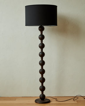 Tall sculptural solid oak floor lamp with barbell design in dark wash finish with black linen drum shade, made in America 