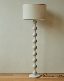 Tall sculptural solid red oak floor lamp with barbell design in white wash finish with ivory linen drum shade
