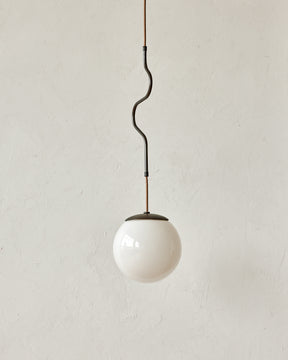 Modern black globe pendant light with dark oil rubbed brass curved body and white milk glass globe